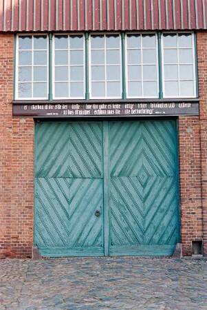 Fritz-Berodt-Straße 7-9: Hofanlage: östliches Wirtschaftsgebäude: Giebelseite, Teilansicht: Scheunentor, auf Torsturz Inschrift, darüber Fensterband mit Sprossenfenstern, oben Verbretterung
