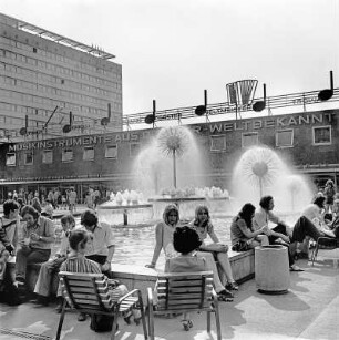 Wasserspiel mit Pusteblumen (Kugelbrunnen) : Dresden. Sich Ausruhende am Brunnenrand der Wasserspiele "Pusteblumen"