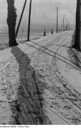 Fahrspuren im Schnee auf einer leeren Straße
