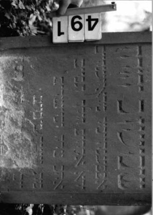 Grabstein 491 (Index: 99803812) Material: Sandstein Zustand: unten abgeblättert/Textverlust Maße HxBxT: 112x59x12 cm Beschreibung: Stele mit verdacht. Rundbogen und profiliertem Rand, Giebelfeld: Grabstein 491 (Detailaufnahme)