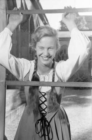 Basel, Schweiz: Komödie Basel; Immy Schell als "Gretchen" im Klosterhof des Münsters (lachend, Arme hoch am Gitter)