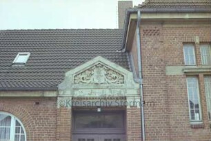 Schulstraße: Schlossschule [später Grundschule am Schloss]: Turnhalle: Detailaufnahme: Supraporte über Eingang, mit Namenszug und Wappen