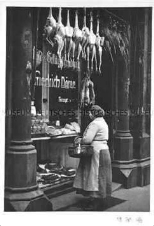 Frau vor einem Schaufenster mit Lebensmitteln
