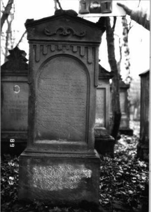 Grabstein 101 (Index: 99751873) Material: Sandstein Zustand: leicht verwittert Maße HxBxT: 146x50x26 cm Beschreibung: giebelart. Abschl. m. Mittel-u. Eckakrot. , Schriftfeld eingetieft m. Rundbogenabschluß Symbolik: Ranke, gestelztes Rundbogenfries Besonderheit: Zitat Hiob 1, 8 und 2, 3: Grabstein 101