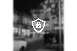 Hindenburgstraße: Adventsbeleuchtung und erleuchtete Wohn- und Geschäftshäuser: links Feinkostgeschäft Peters: hinten Mitte Mühlenstraße mit Kaufhaus Nickel: davor Personen und Pkws: Abend