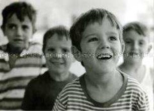 Porträt eines kleinen Jungen, im Hintergrund weitere Kinder