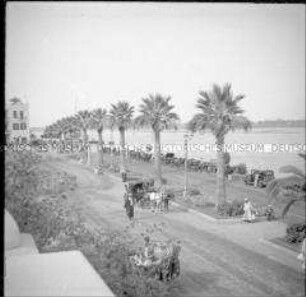Passanten und Pferdedroschke auf einer Uferpromenade am Nil, Luxor, Ägypten