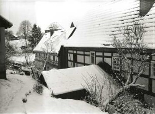 Elbsandsteingebirge. Hintere Sächsische Schweiz. Fachwerkbauten im winterlichen Dorf. Vermutlich Hinterhermsdorf oder Saupsdorf
