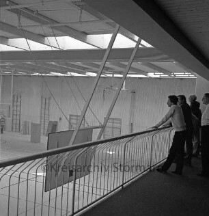 Bargteheide: Kreisgymnasium II [später Gymnasium Eckhorst]: Eckhorst: Sporthalle: vor Fertigstellung: Innenaufnahme: Besichtigung durch Kreispräsident Hubert Priemel, Landrat Hans-Henning Becker-Birck, Fachleute beim Blick von Galerie in Halle