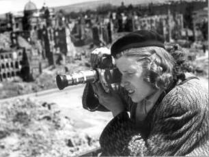 Renate Winkler (später Rössing) mit Baskenmütze und Kamera vor Ruinen