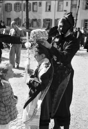 St. Peter: Trachtenfrau und Kommunionkind; Kind sieht zu