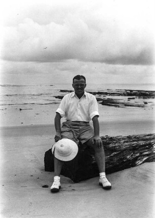 Männerportrait : Portraitaufnahme Dr.Günter Wolffs auf einem verwitterten Edelholzblock sitzend, der sich an einem Strand bei Bata befindet.