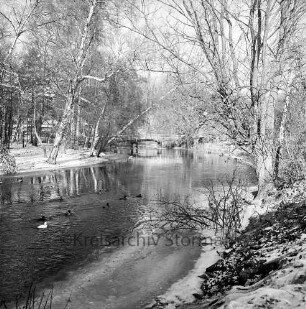 Trave: Stadtarm: links der Bürgerpark, hinten die Fußgängerbrücke nördlich der Straßenbrücke des Konrad-Adenauer-Ringes: Blick nach Süden: Winterbild