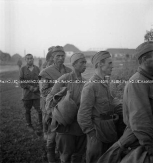 Russische (?) Kriegsgefangene stehen in einer Schlange