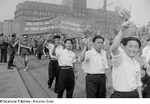 Asiatische Teilnehmer im Demonstrationszug beim Vorbeimarsch an der Ehrentribüne auf dem Karl-Marx-Platz (heute: Augustusplatz), im Hintergrund das Kroch-Hochhaus