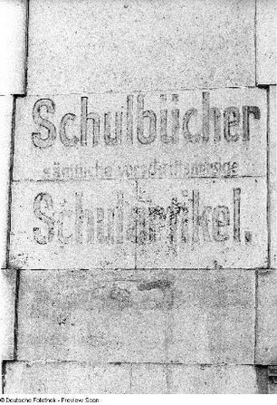 Inschrift "Schulbücher. Schulartikel" an einer Hauswand
