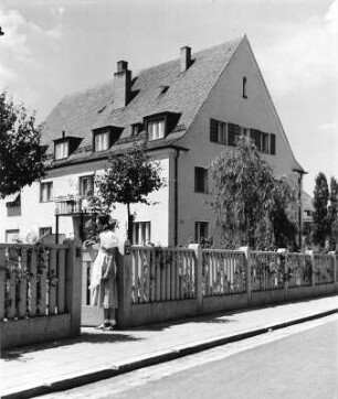 Div. Häuser : Diverse Häuser. Straßenansicht eines Wohnhauses (um 1930). Ansicht mit jungem Mädchen am Gartentor