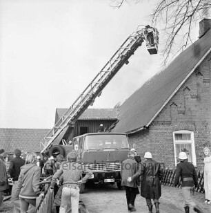 Brand: Gehöft des Landwirt Gerhard Feddern: Löscharbeiten: Einsatzfahrzeug, Feuerwehrleute und Schaulustige (links) vor dem brennenden Gebäude