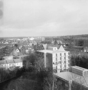 Blick vom Hauptgebäude des LVA-Krankenhauses Großhansdorf der Landesversicherungsanstalt Hamburg [später: LungenClinic Grosshansdorf] Richtung Nordosten: Wöhrendamm: vorn Mitte und rechts Wohnblocks für Personal: dahinter Volksschule Wöhrendamm: dahinter U-Bahn-Station Großhansdorf der U-Bahn-Linie U 1: hinten links Wohn- und Geschäftshäuser am Eilbergweg: dahinter Mitte Wohnblocks des Rosenhofs: hinten rechts Eilbergwald