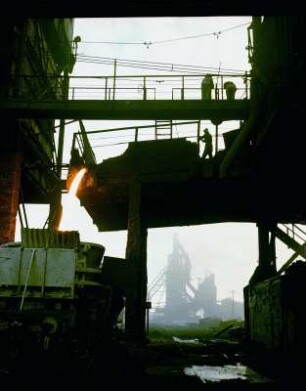 Schlackenabstich. Hochöfner auf Verbindungsbrücke des Hochofens des VEB Eisenhüttenkombinat Ost (EKO)