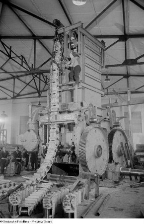Arbeiter während des Aufbaus einer Maschine in einer Messehalle der Technischen Messe