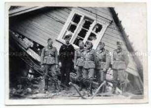 Gruppenbild von Soldaten vor einem zerstörten Haus