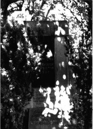Grabstein 126 (Index: 100105331) Material: Granit, schwarze Platte Zustand: gut Maße HxBxT: 201x158x14 cm Beschreibung: Stele, beidseitig von halbhohen Flügeln umfaßt, leicht überstehende Abdeckplatte, rechteckige Schriftplatte, vor Stele liegend rechteckige Gedenktafel Besonderheit: Doppelgrab für Eheleute und Gedenktafel: Grabstein 126