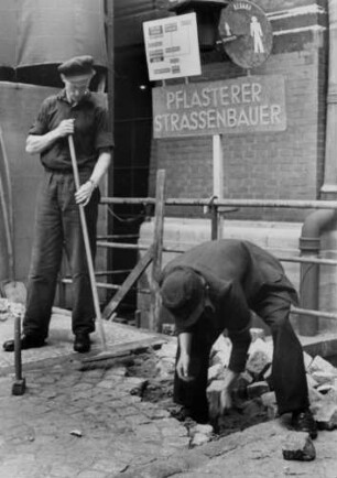 Ausstellung "Jugend, dein Beruf" 1950 in Hamburg. Lehrlinge pflastern einen Weg. Sie werden einmal tüchtige Pflasterer und Straßenbauer