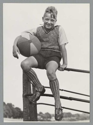 Portrait eines Jungen mit Pullunder und Ball