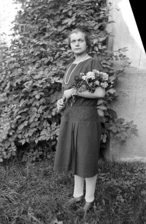 Frau mit Blumenstrauß in einem Garten