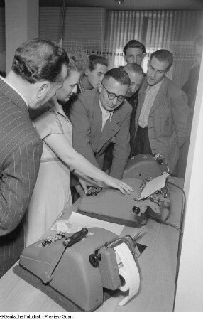 Besucher bei der Vorführung einer Addiermaschine des VEB Büromaschinenwerk Rheinmetall Sömmerda, Internationale Ausstellung für Buchgewerbe und Graphik (Bugra) 1953