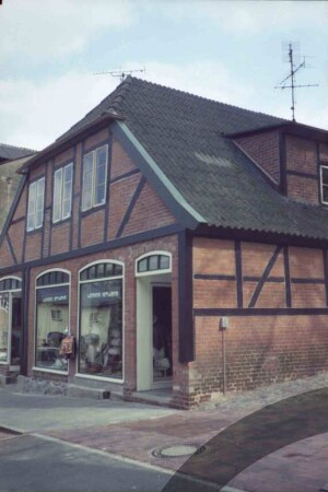 Hude 2: giebelständiges Fachwerkhaus: Straßenfront mit Schaufenstern von Geschäft "Leder Studio": Traufseite