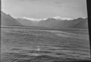 Bergpanorama : Panoramablick auf einen See, im Hintergrund Gebirgszüge mit schneebedeckten Gipfeln