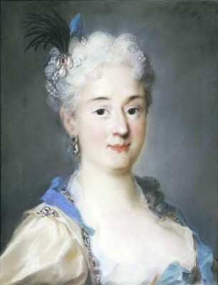 Eine Dame in mattgelbem Kleid mit hellblauen Schleifen