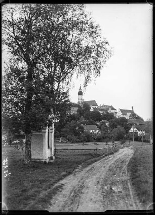 Andechs. Stadtteilansicht mit Wohnhäusern und Blick zur spätgotischen Klosterkirche