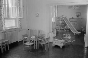 Zwei mit Spielzeug und Sitzmöbeln ausgestattete Zimmer eines Kindergartens