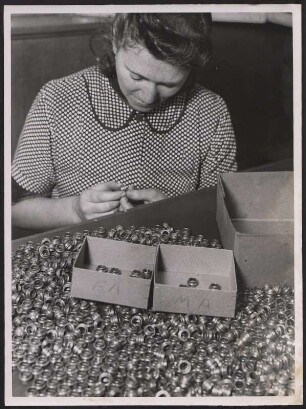 Frau beim Aussortieren von Bauteilen
