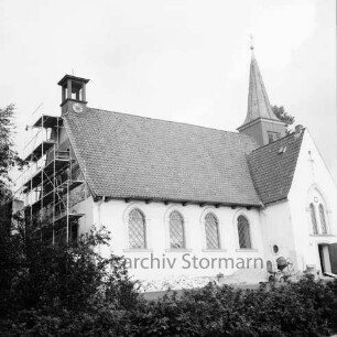 Matthias-Claudius-Kirche: Paul-von-Schoenaich-Straße: Renovierung: Außenaufnahme: Blick von Südwesten: Erneuerung des Außenputzes an westlicher Giebelwand, Gerüst, Zementmischmaschine: im Vordergrund Hecke