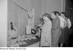 Besucher vor einer Vitrine mit Herrenoberbekleidung
