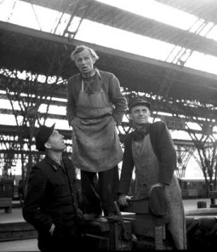 Gruppenportrait dreier Männer beim Abschied am Leipziger Hauptbahnhof