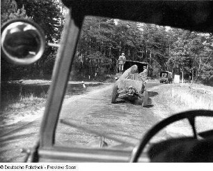 Deutschland . Truppenübungsplatz Klietz. Nationale Volksarmee - Landstreitkräfte. Marschkolonne der Artillerie. Blick aus einem Fahrerhaus auf vorausfahrenden Lastkraftwagen mit angehängtem Geschütz