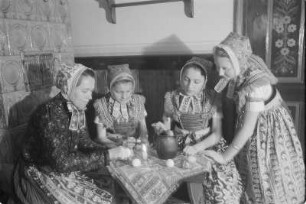 Schleifer Frauen und Mädchen in Schleifer Tracht beim Verzieren von Ostereiern. : Holcy a žony w Slepjanskej drasće při debjenju jutrownych jejkow pola Wěrikec w Rownom.