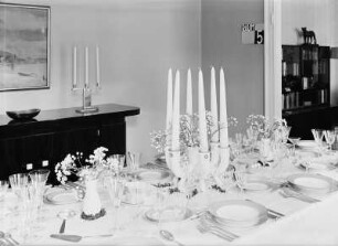 Innenraum mit gedecktem Tisch (1925/1930; Deutsche Werkstätten Hellerau). Hochzeits-Festtafel in einem Speisezimmer, Sechsarmiger Kerzenständer