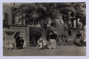Reisefotos. Italien. Straßenbild mit Palmen (vielleicht in San Remo). Ansicht mit Kindermädchen