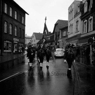 Schützenfest: Veranstalter Schützenverein Reinfeld und Umgebung von 1954 e.V.: Umzug: Paul-von-Schoenaich-Straße: Tiroler Schützen der Schützenkompanie Wilten (bei Innsbruck), mit Fahne: beiderseits Zuschauer mit Regenschirmen: rechts parkendes Auto, Geschäft "Harten", 8. September 1974