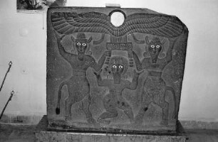 Gilgamesch zwischen zwei Stiermenschen die eine geflügelte Sonnenscheibe tragen