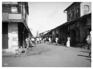 Colombo (Sri Lanka). Ladenstraße mit Rikschafahrer und Passanten