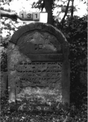Grabstein 131 (Index: 100110708) Material: Sandstein Zustand: sehr stark verwittert mit Abschieferungen, sehr großer Textverlust etwas eingesunken Maße HxBxT: 116x75x14 cm Beschreibung: Stele, Rundbogenabschluß, Schriftfelder eingetieft: Grabstein 131