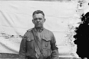 Frontales Halbfigurenporträt eines SA-Truppenführers (Feldwebels) des Sturmes 23 der Reserve-Standarte 102 : "R" vor der Nummer der/ SA-Mitglieder im Alter von über 45 Jahren/ aufgenommen vor einem aufgespannen weißen Tuch, diente die Aufnahme vermutlich einem Ausweisbild