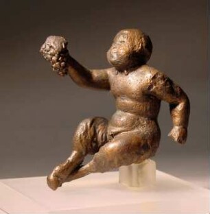 Römische Statuette des kindlichen Pan; sitzend, mit Weintraube